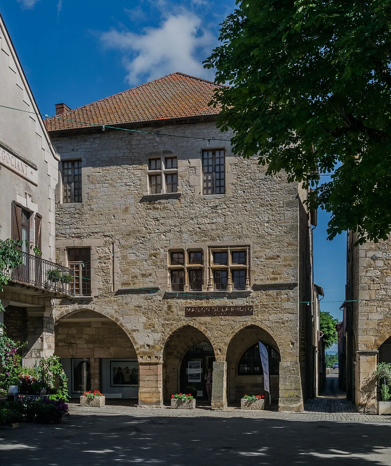 Façade en pierre à arcades ogivales de la demeure médiévale de la place des Conques, qui abrite la galerie Jean-Marie Périer