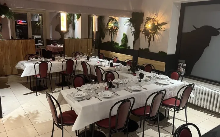 Salle du restaurant dressée pour un repas de groupe